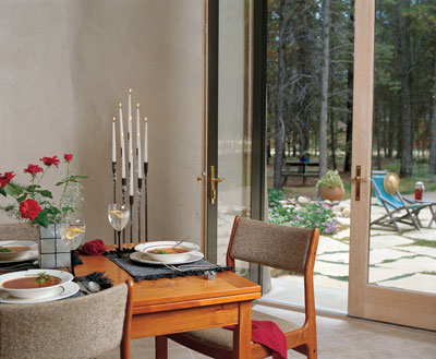 
“The softness of the walls does wonderful things to candlelight.­” says Ann. “Our biggest expense is not electricity, it’s candles.” The eight-foot French doors to the patio are from a salvage yard.
